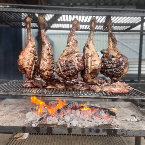Legs of lamb cooking over open fires at Drovers Rest